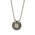 Silver necklace with a round pendant on a white background